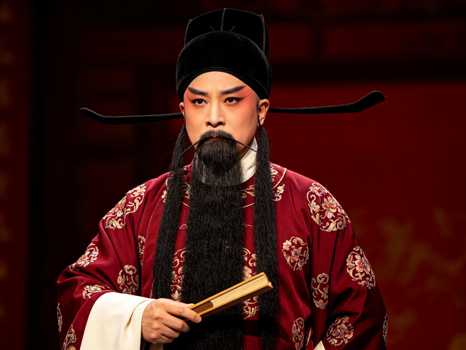 京剧《海瑞罢官》马派老生海瑞戴乌纱、挂黑三髯、身穿绛红团花官衣，手持笏板、神色刚正威严