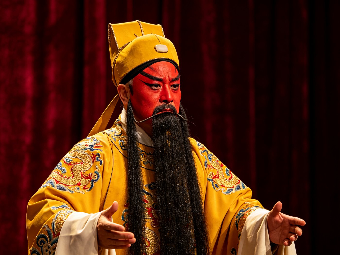 京剧《斩黄袍》高派红生赵匡胤勾红脸、挂黑三髯、戴王帽、身穿明黄团龙蟒袍，双手微张作酒后追悔状